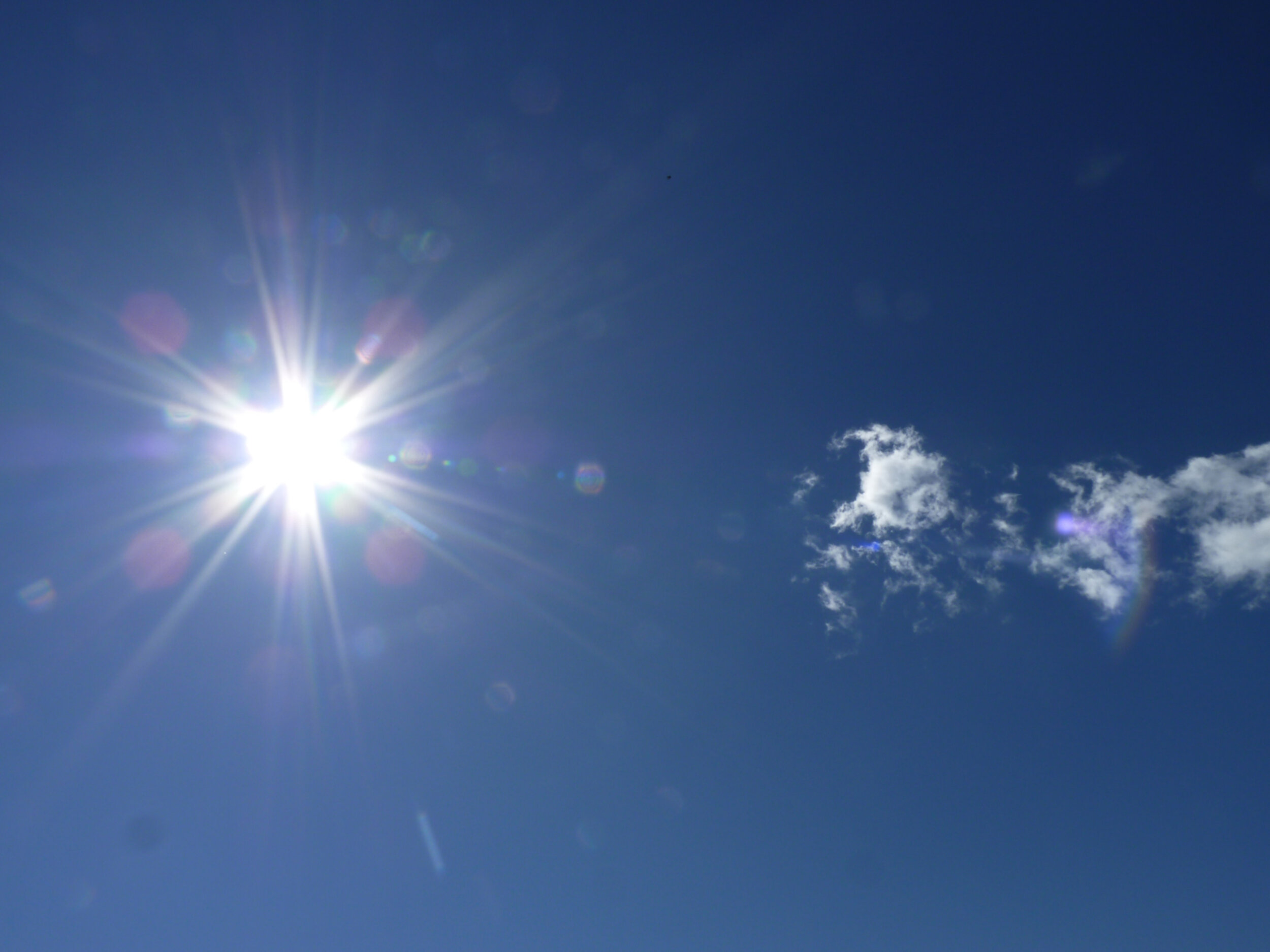 Blauer Himmel mit Sonne und Wolken